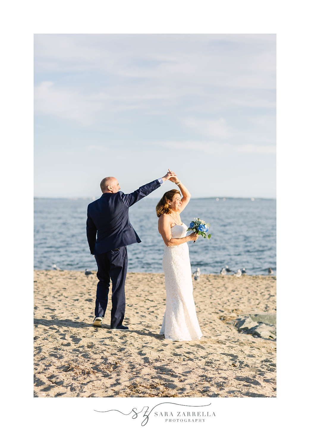 groom twirls bride on beach in Warwick RI