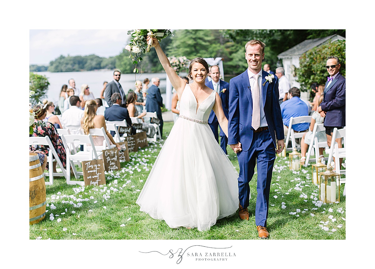 bride and groom walk up aisle after romantic lakeside wedding ceremony
