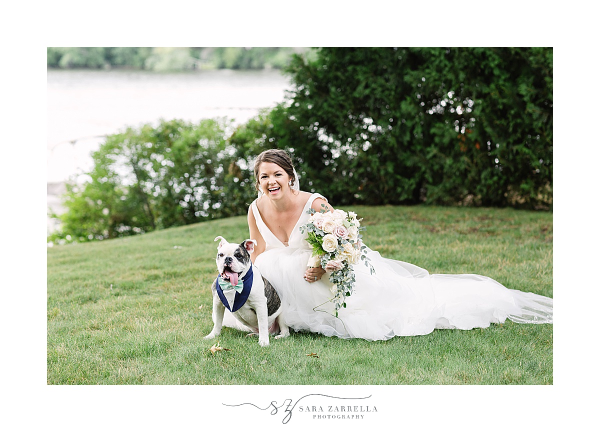 bride poses with dog after romantic lakeside wedding