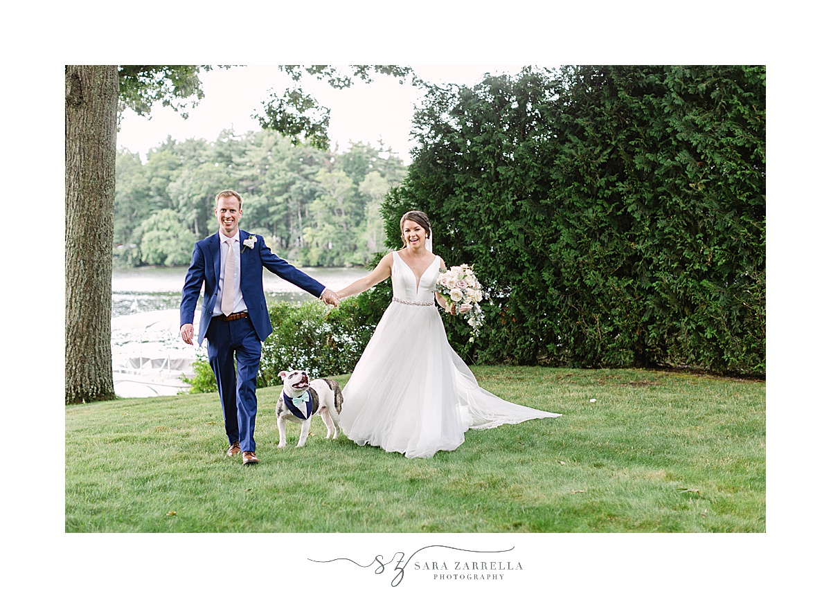 newlyweds walk along lake with dog