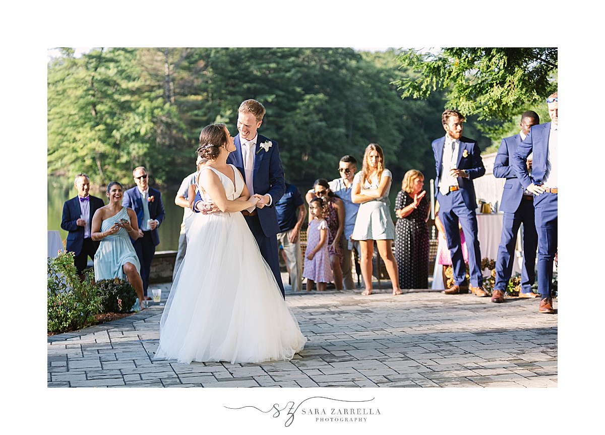 bride and groom dance during lakefront reception
