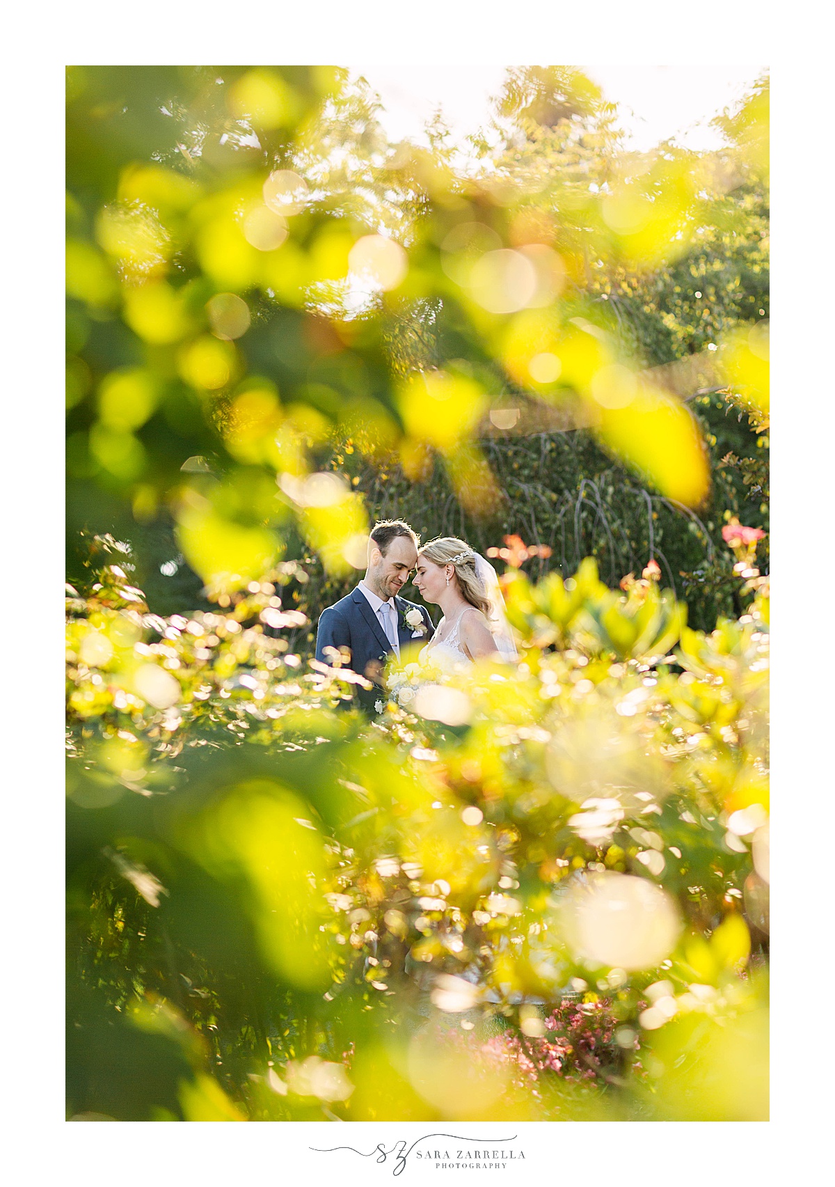 bride and groom pose together in gardens at The Chanler at Cliff Walk
