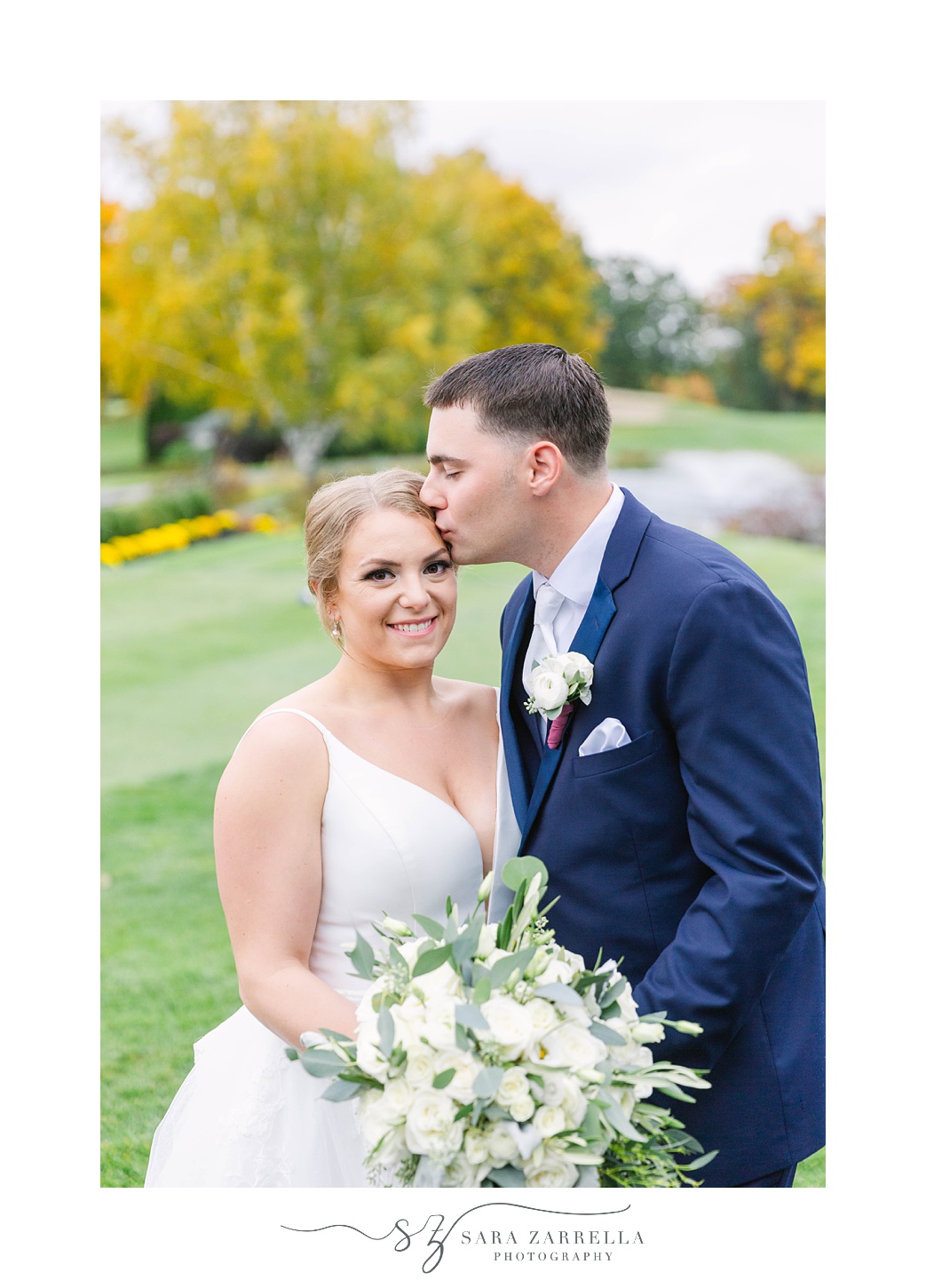 groom kisses bride's forehead during portraits at Kirkbrae Country Club