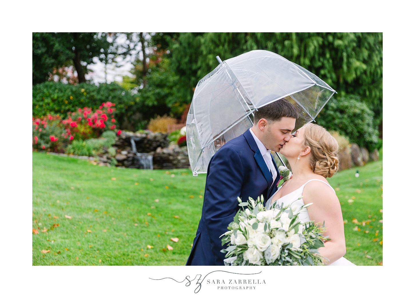 bride and groom kiss under umbrella during rainy Kirkbrae Country Club wedding