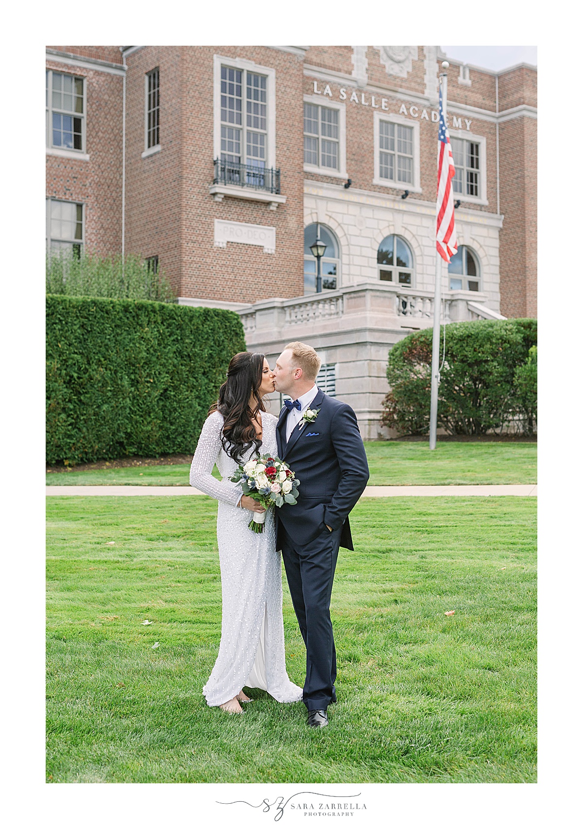 newlyweds kiss on lawn at La Salle Academy Chapel