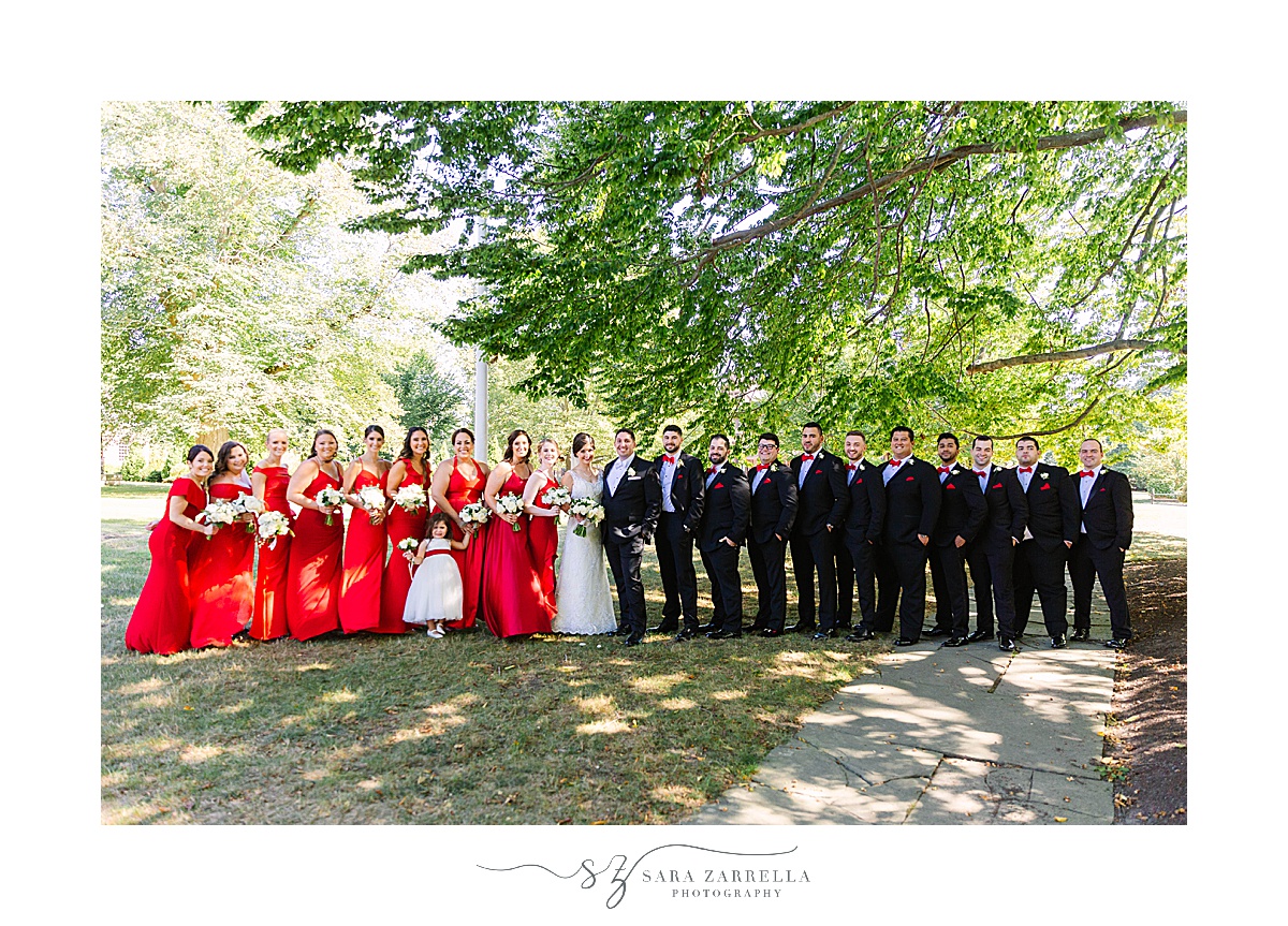 bride and groom pose with wedding party in red and black