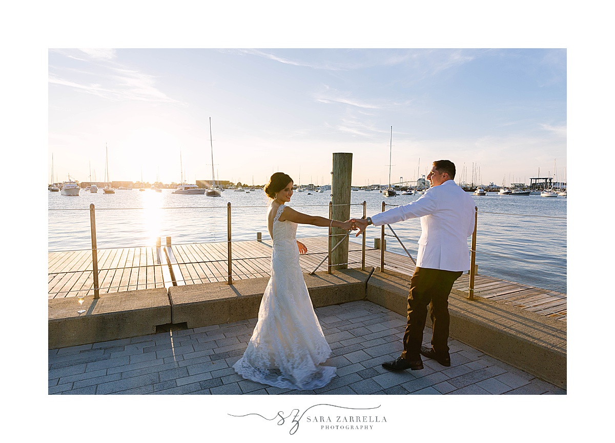 newlyweds dance at sunset along water