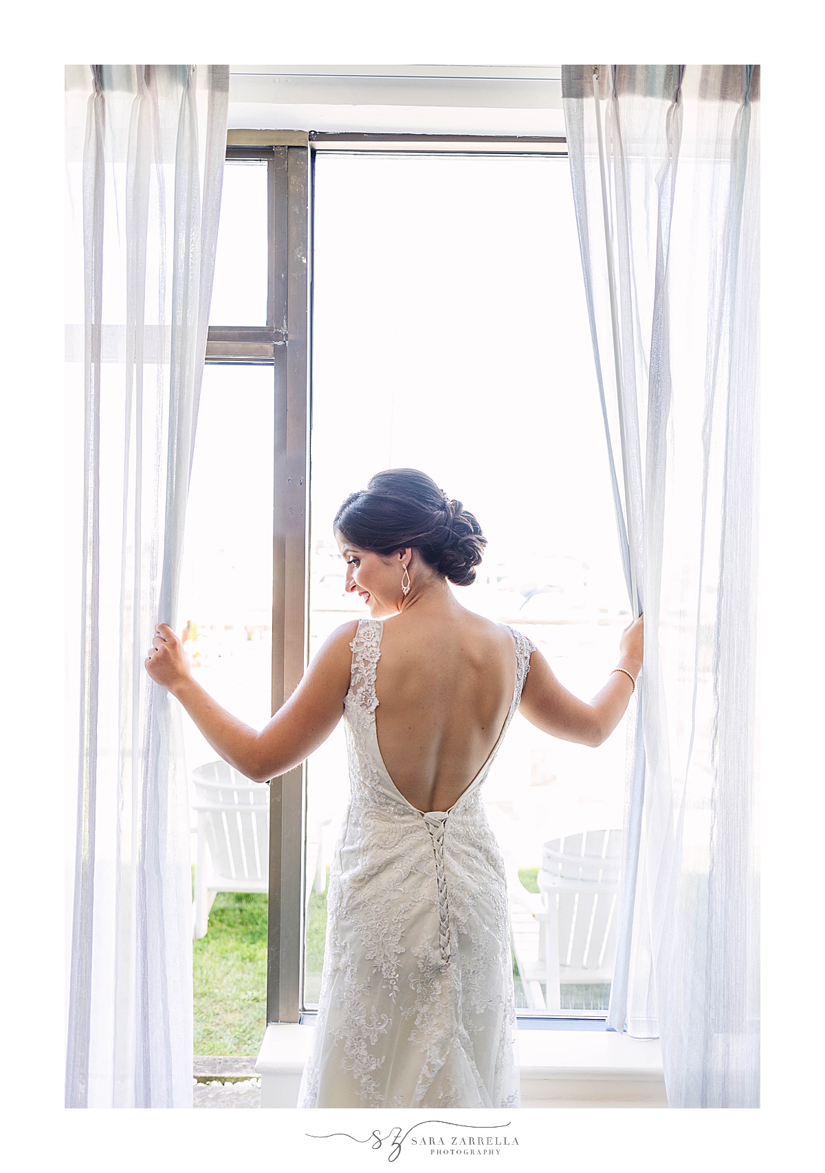 bride looks out window in wedding gown at the Newport Hotel & Marina