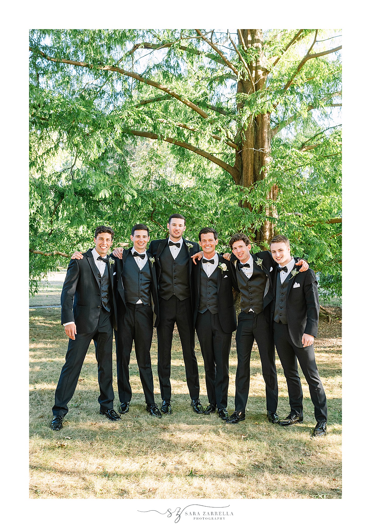 groomsmen laugh with groom during wedding photos