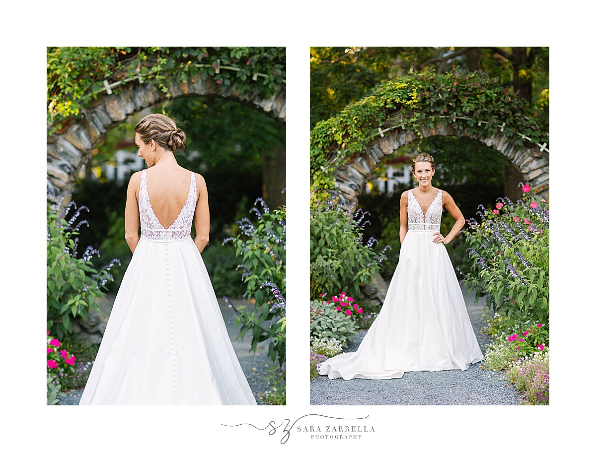 bride poses by stone arch in gardens at Blithewold Mansion