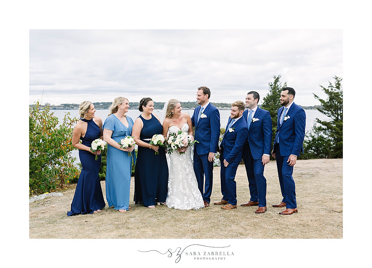 bride and groom smile at each other with bridal party on either side