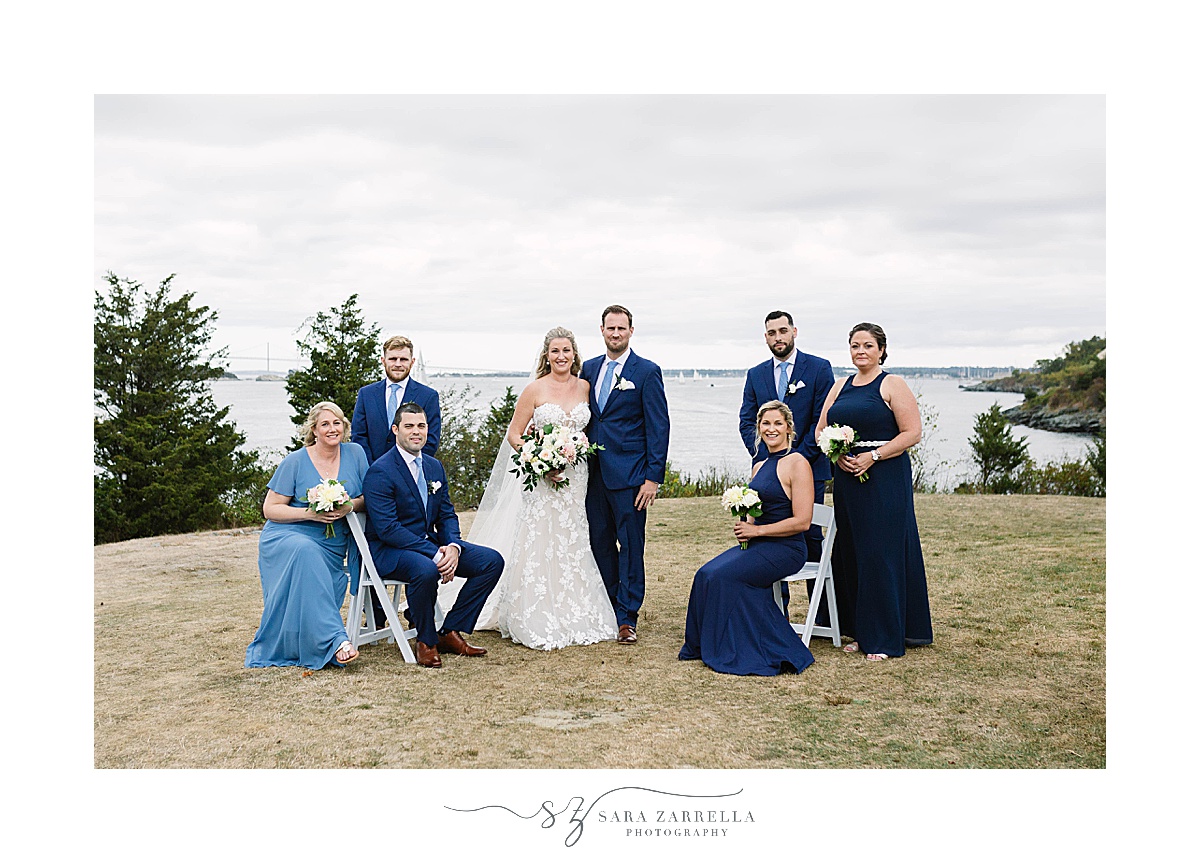 bride and groom pose with bridal party along waterfront at Castle Hill Inn