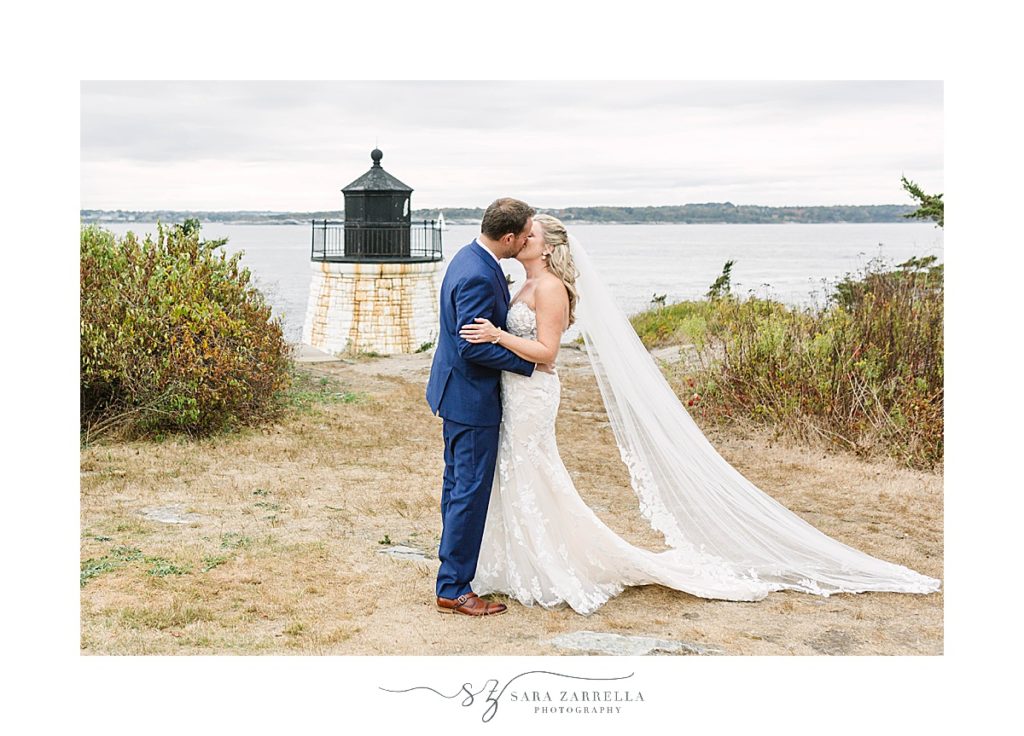 newlyweds kiss with Castle Hill Lighthouse in background 