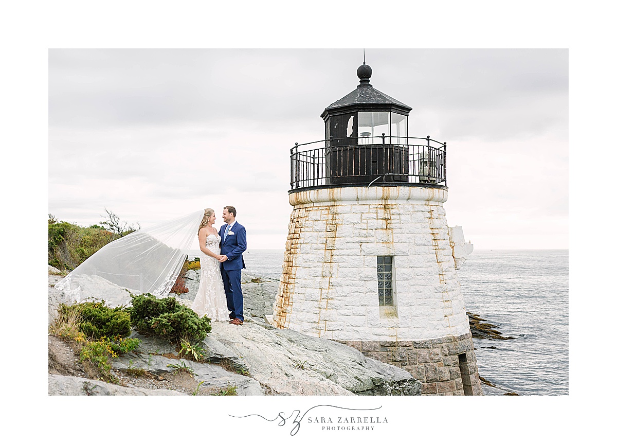 bride's veil floats in wind during portraits at Castle Hill Lighthouse