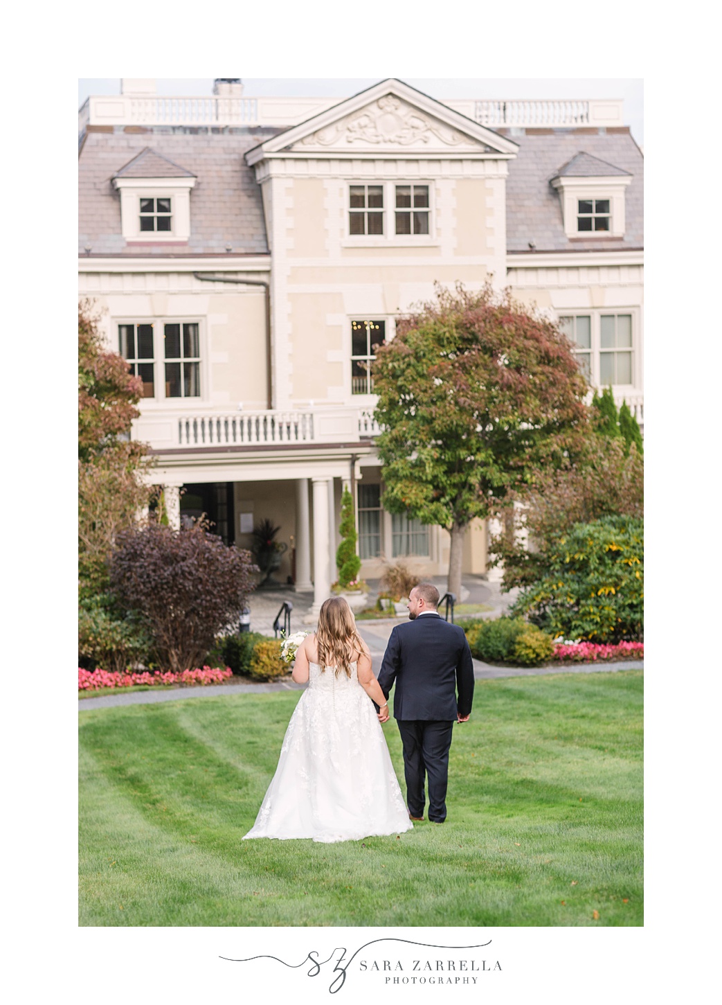 couple walks on lawn in Newport RI before wedding reception