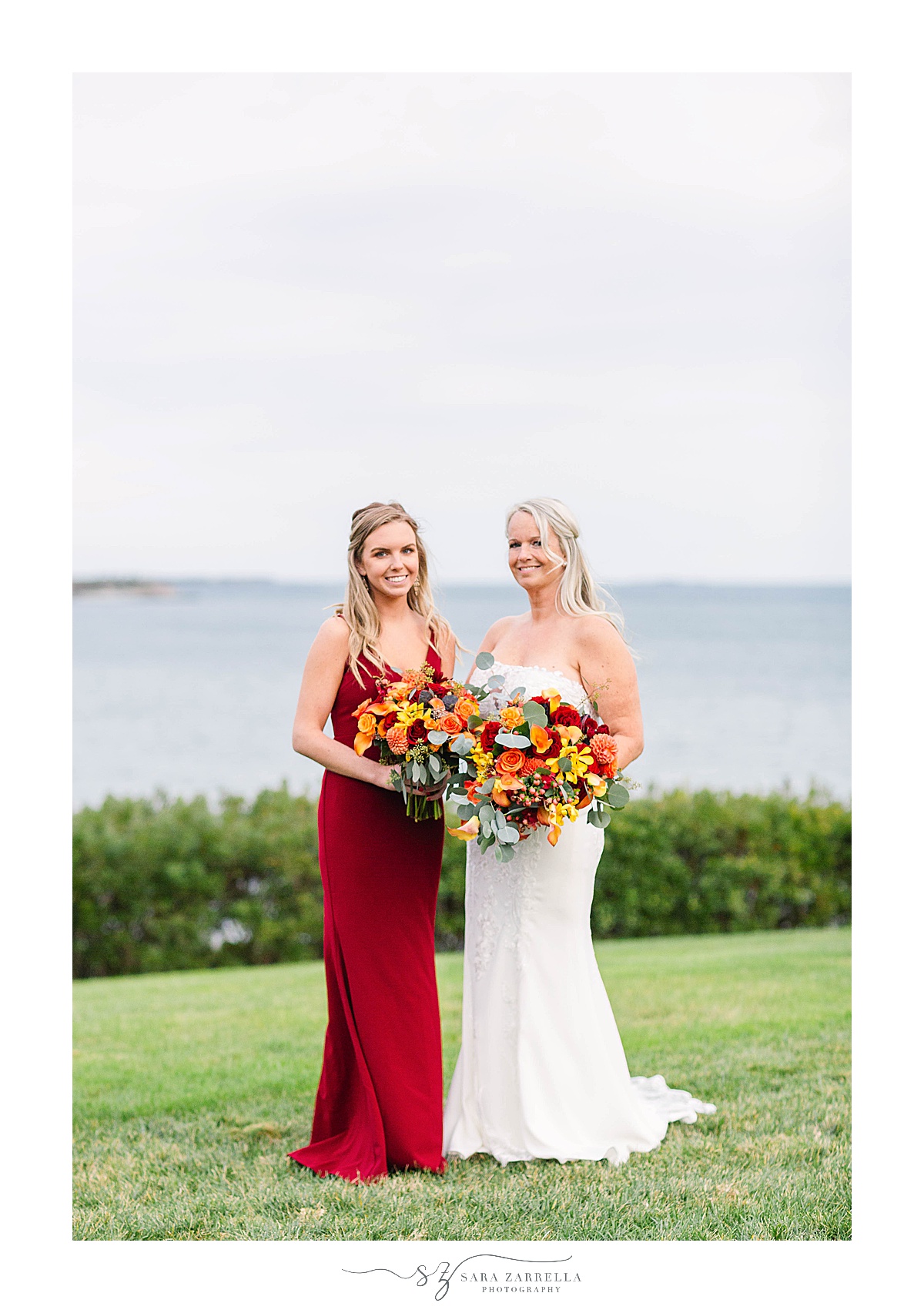 bride poses with bridesmaid during fall wedding