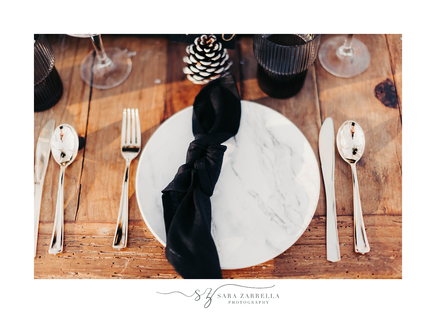 place settings for winter proposal with black napkin and pinecones