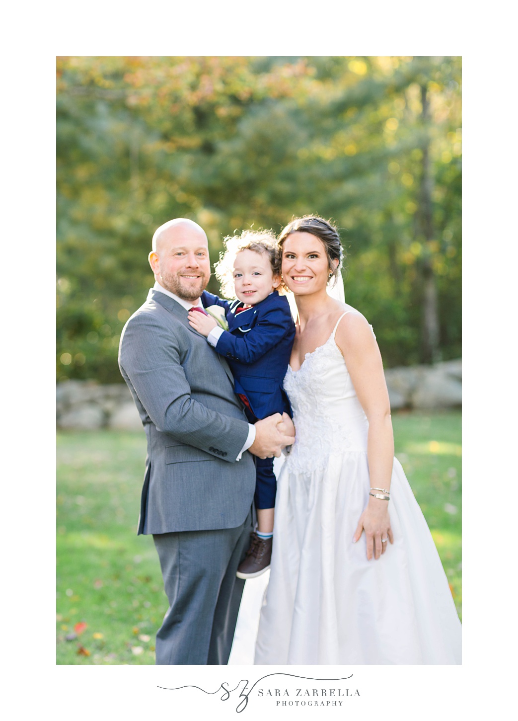 bride and groom pose with ring bearer