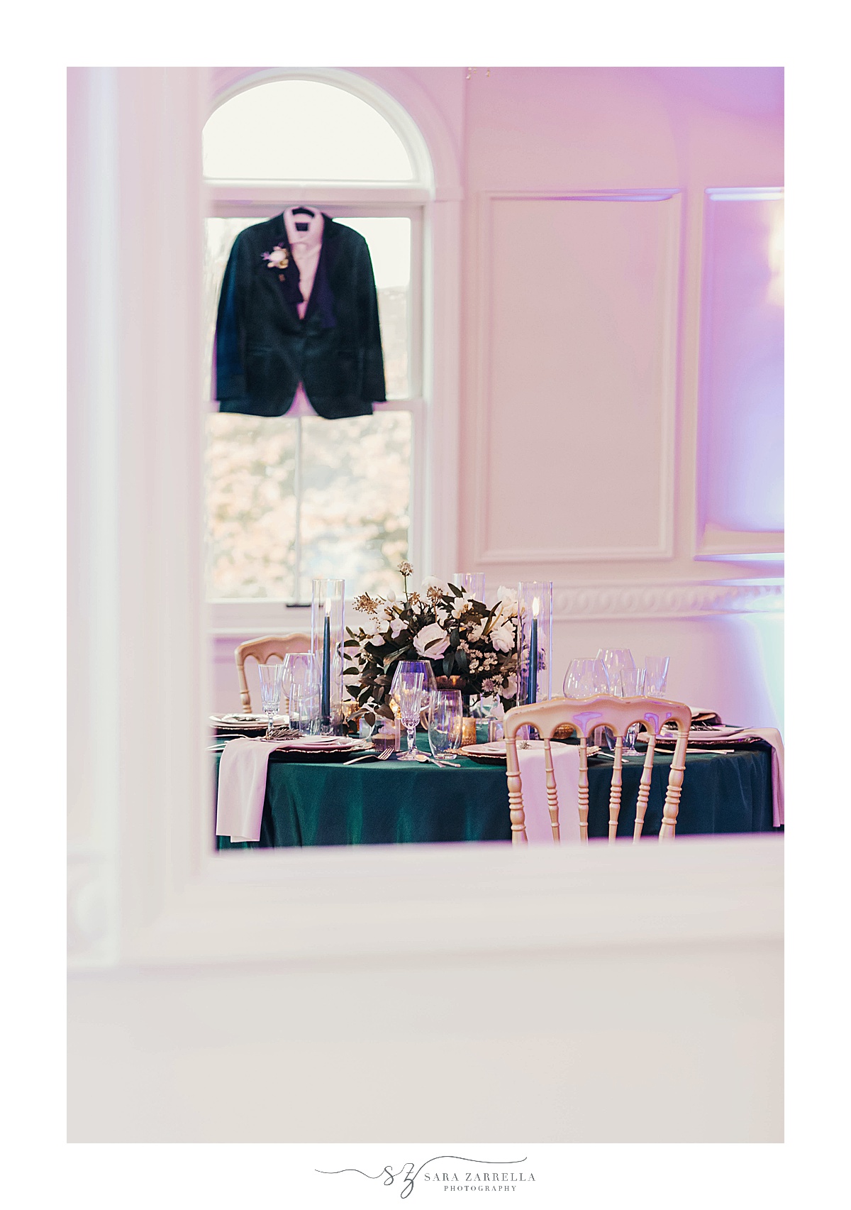 groom's emerald green tux hangs in window at Queen Anne's Loft