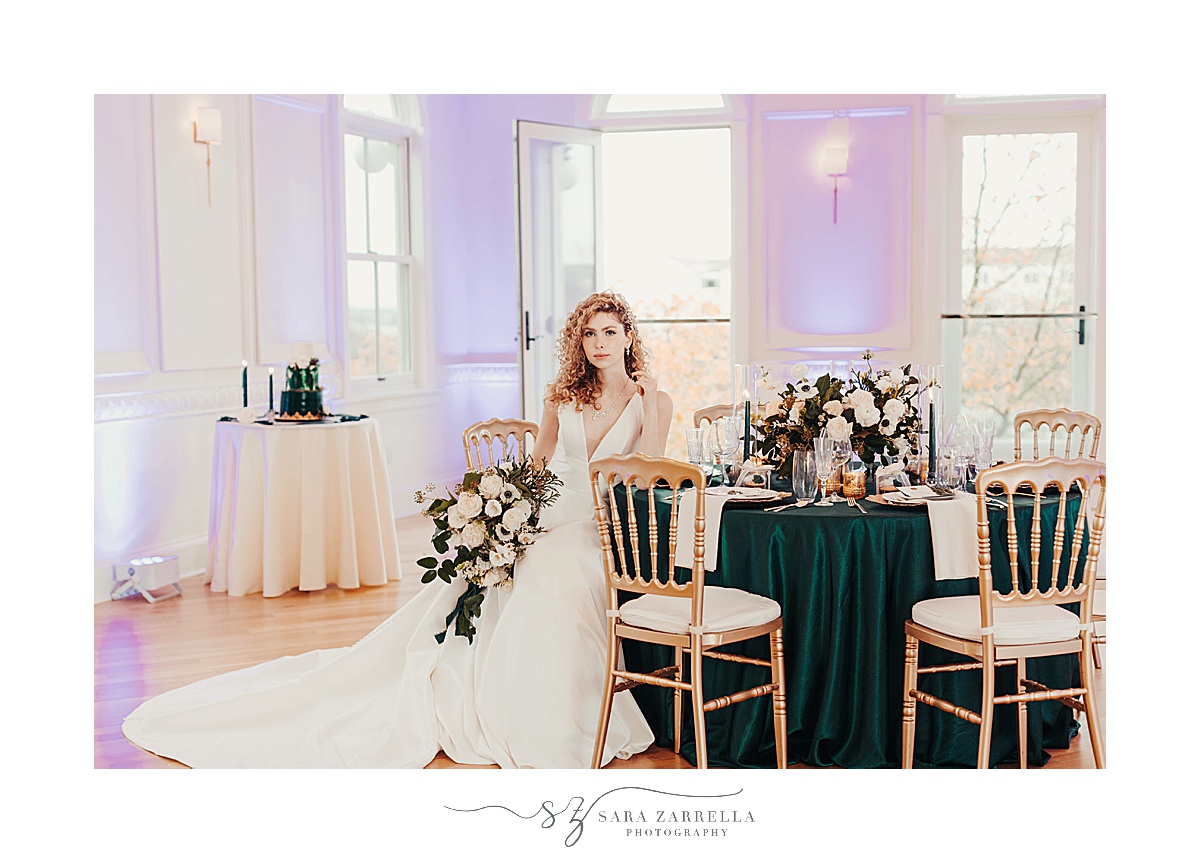 bride sits at table with emerald table cloth