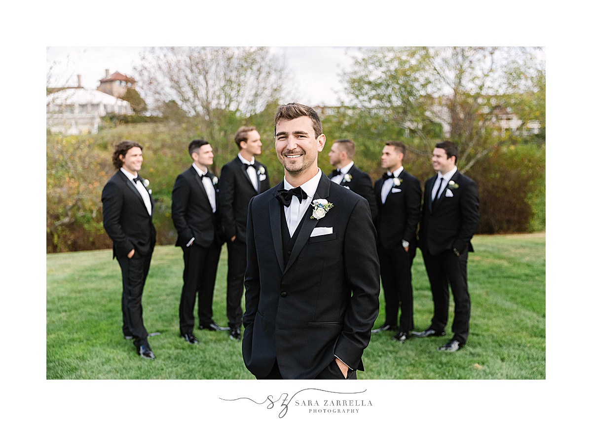 groom poses with six groomsmen in tuxes