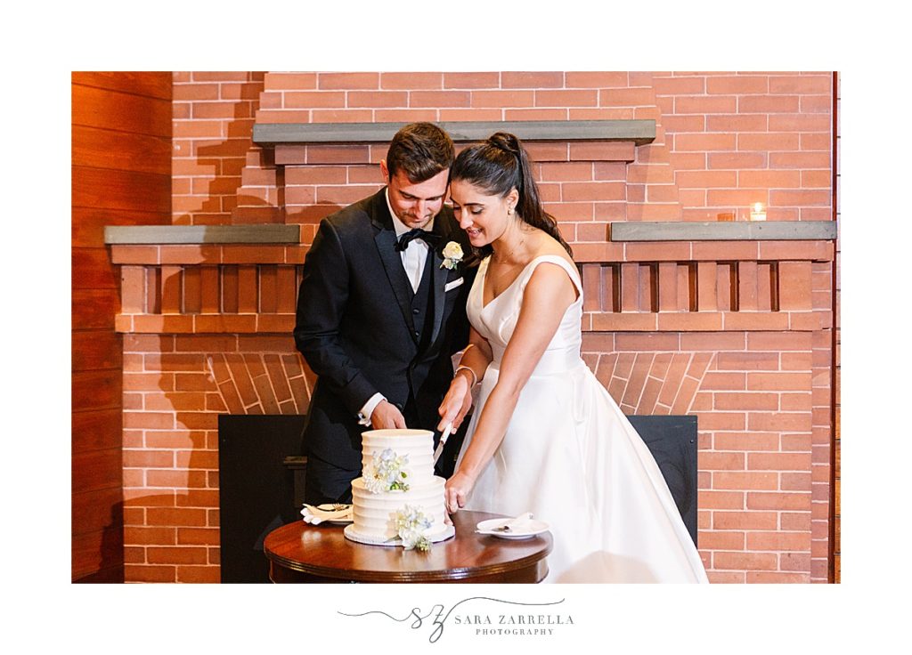 newlyweds cut wedding cake at Castle Hill Inn microwedding