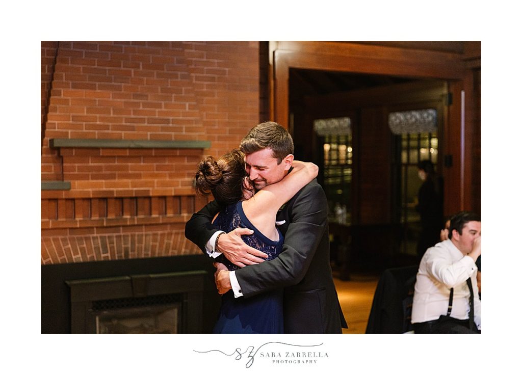 groom hugs mother during wedding reception
