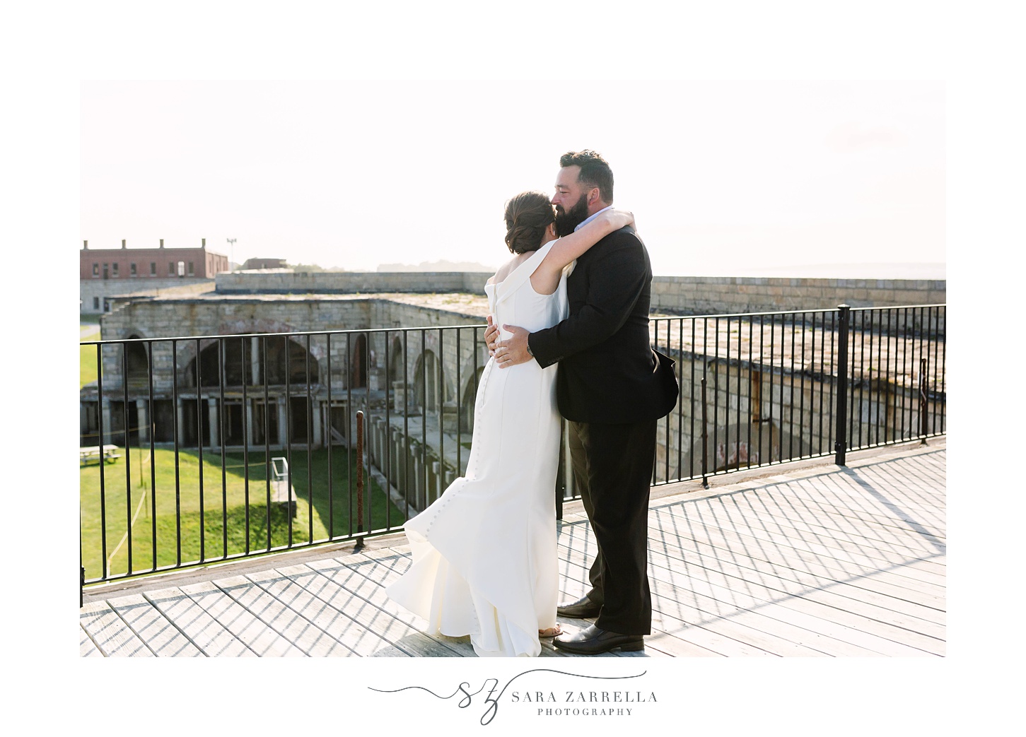 bride and groom hug during first look at Fort Adams