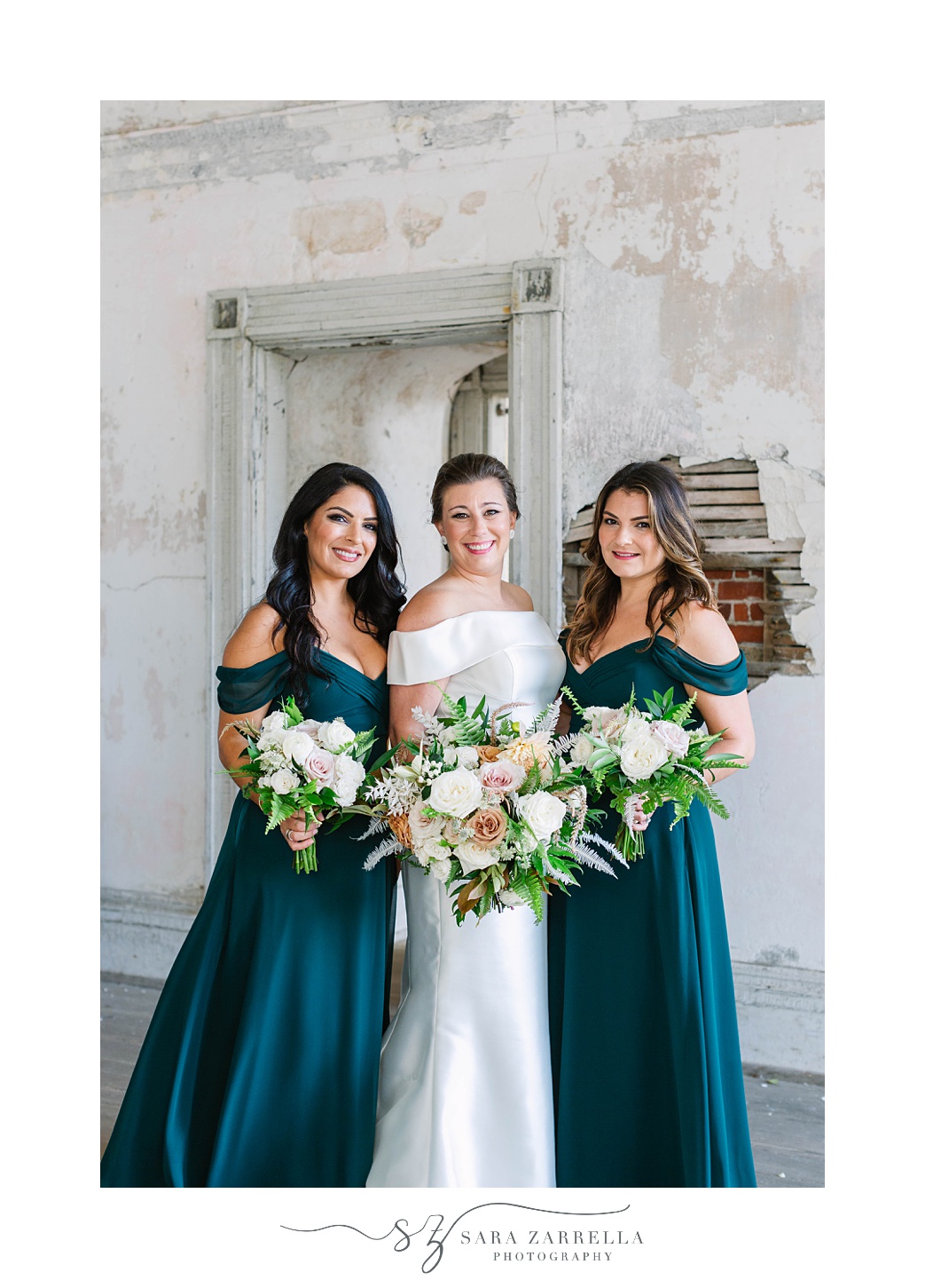 bride poses with bridesmaids in emerald gowns at Fort Adams