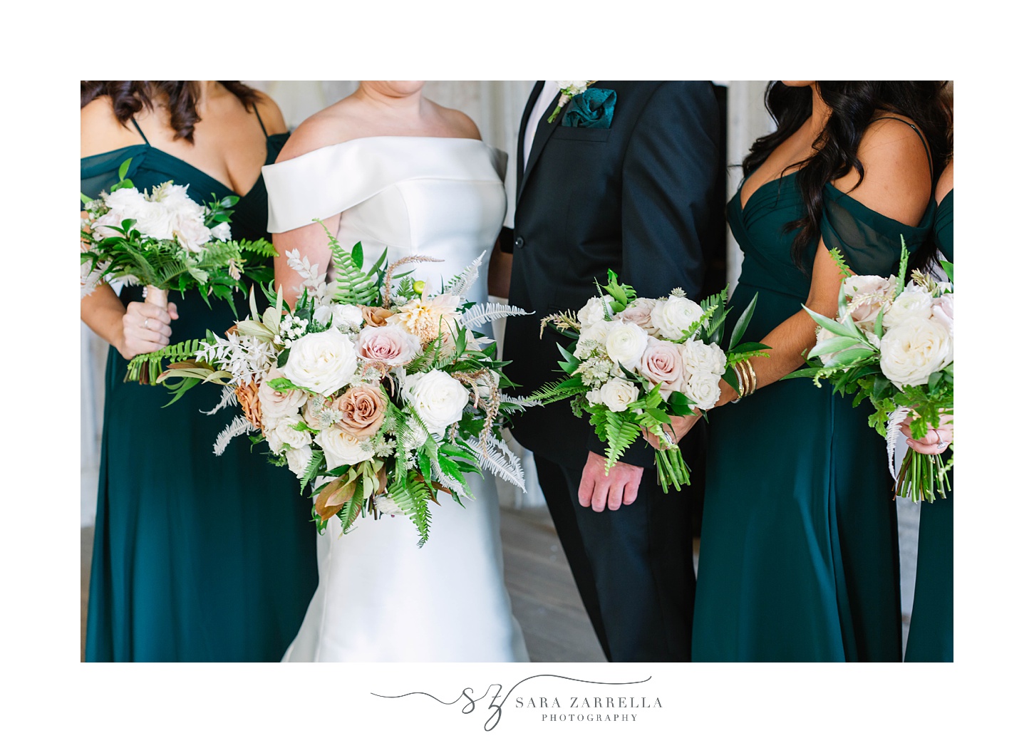 bridal party in emerald green gowns pose in Fort Adams