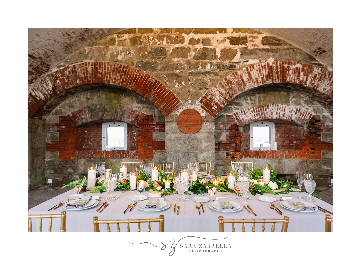 wedding reception table along brick wall at Fort Adams