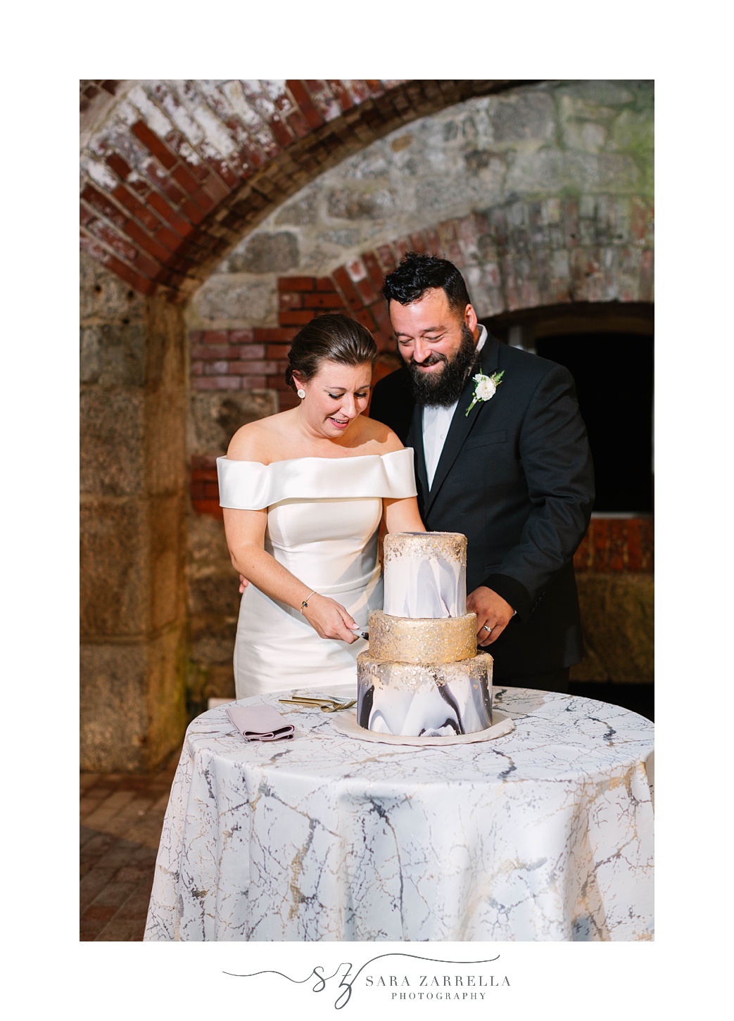 newlyweds cut wedding cake during Fort Adams wedding reception 