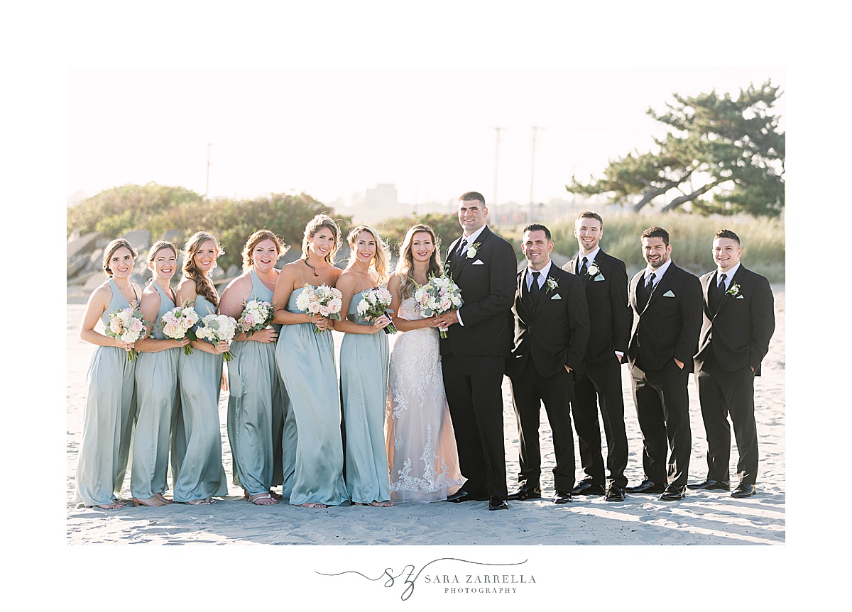 bridal party in black tuxes and green dresses pose at Newport Beach House