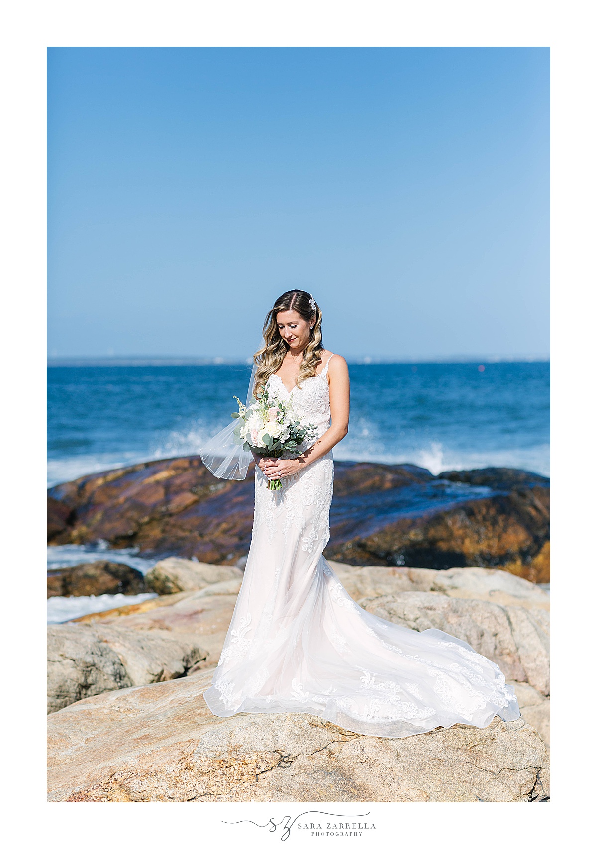 bride poses on cliff at Newport RI