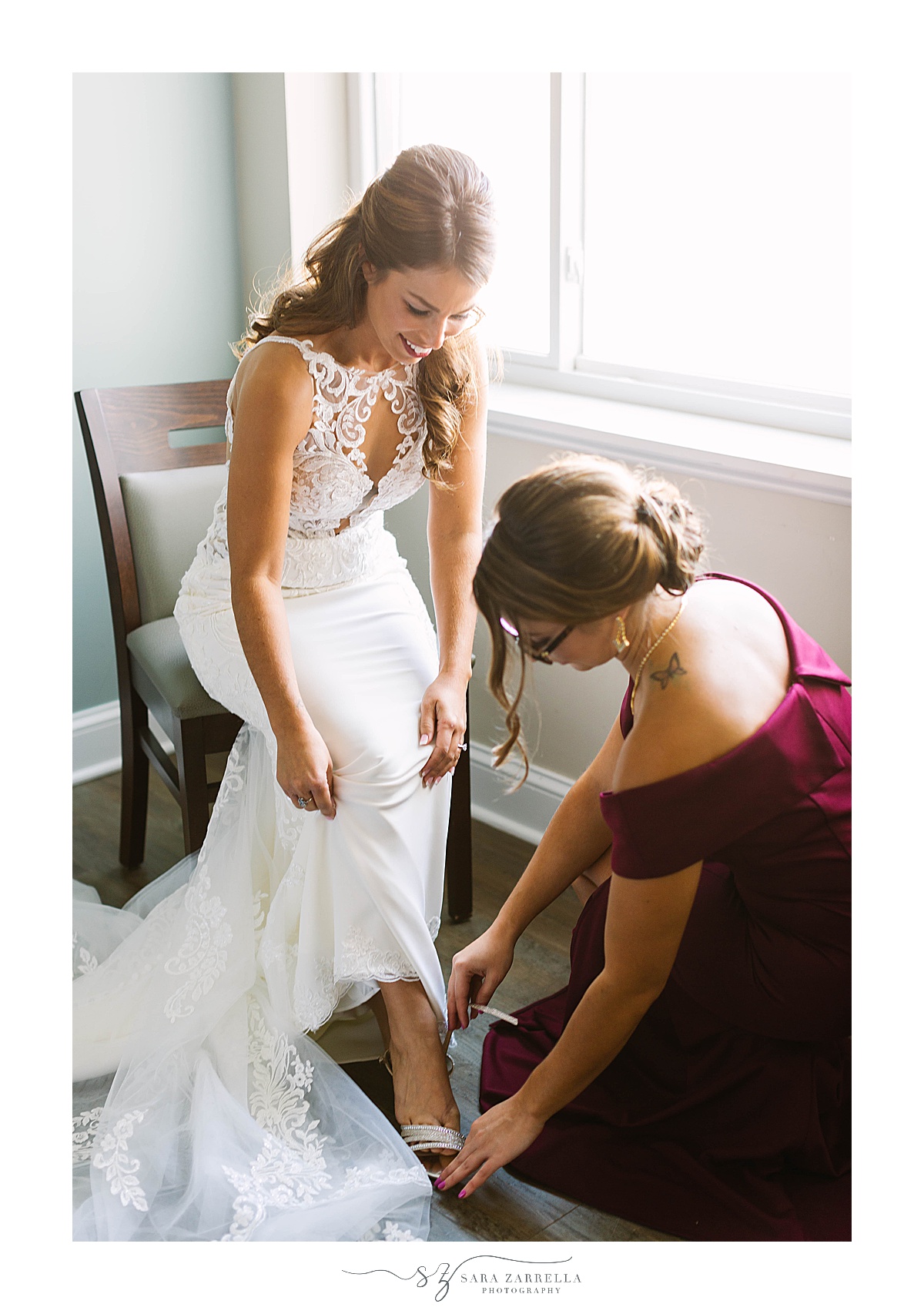 bridesmaid helps bride with shoes on wedding day
