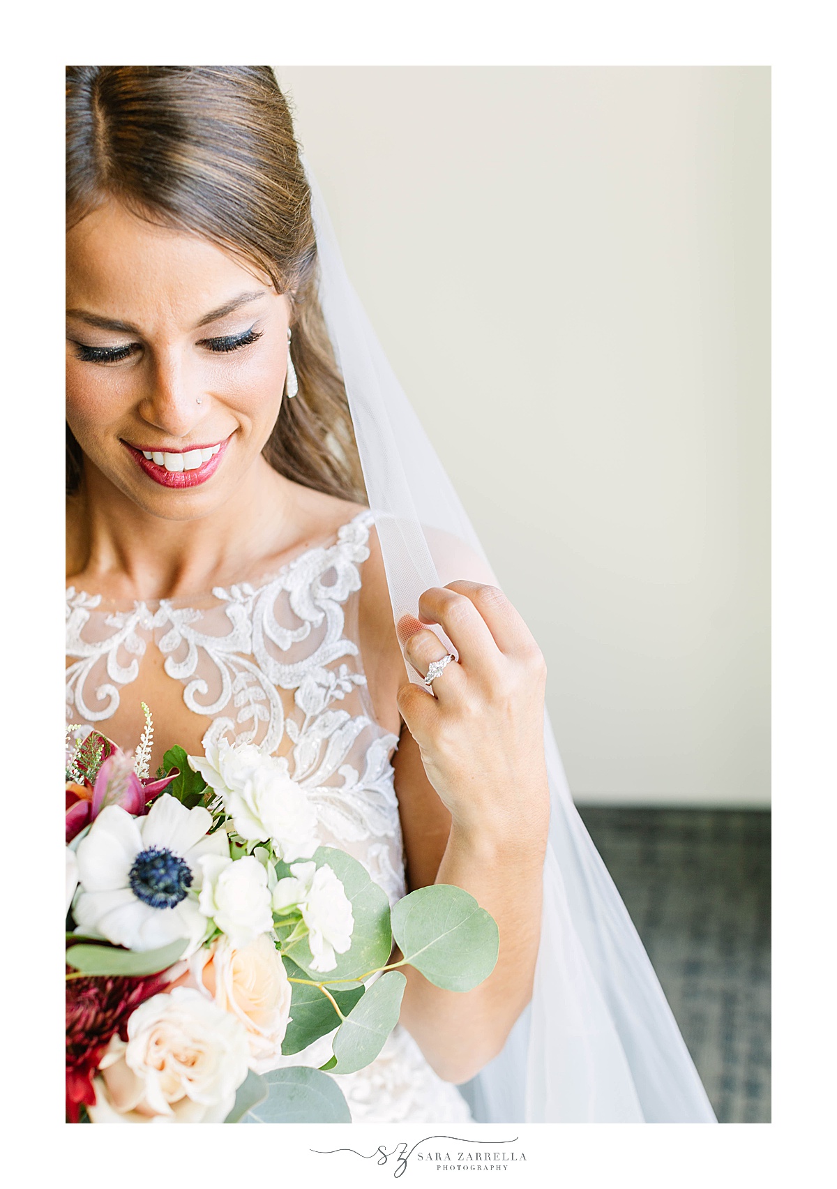 bride moves veil around shoulders during RI bridal portraits