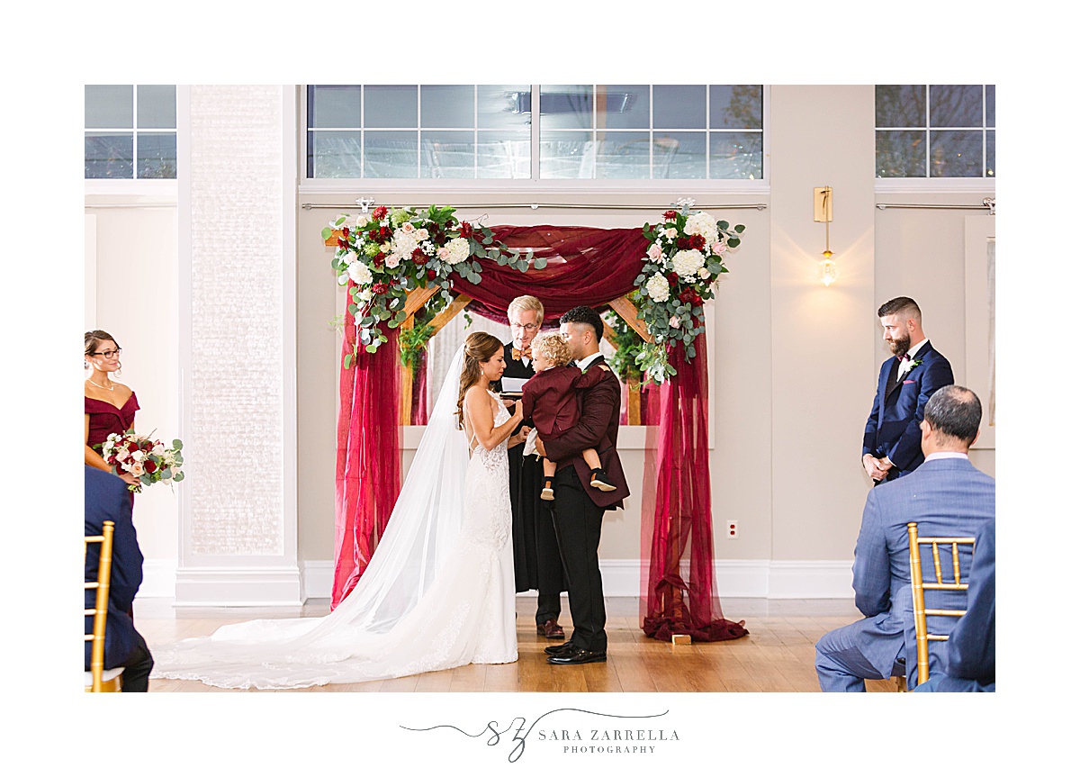 Atlantic Resort Newport Wedding ceremony with arbor and toddler son held by gorom