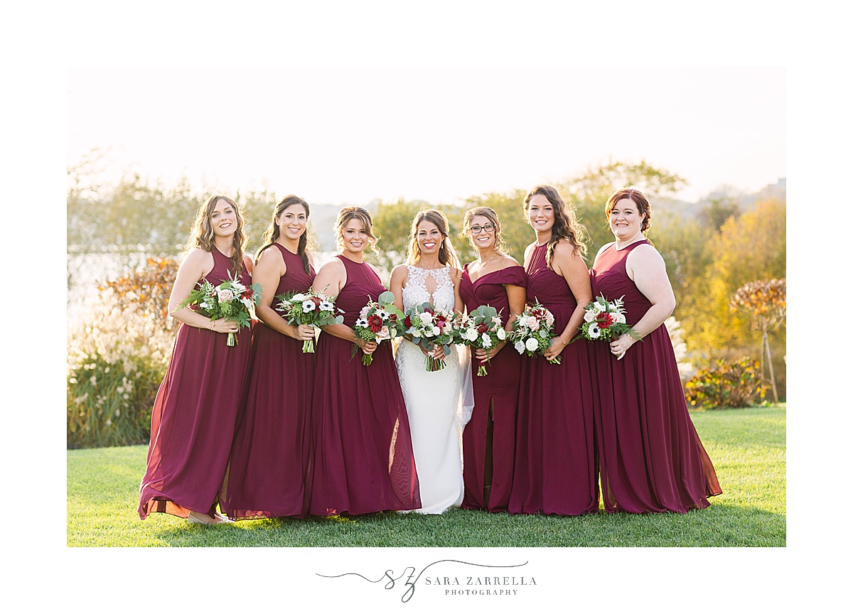 bridesmaids in cranberry dresses pose atter Atlantic Resort Newport Wedding