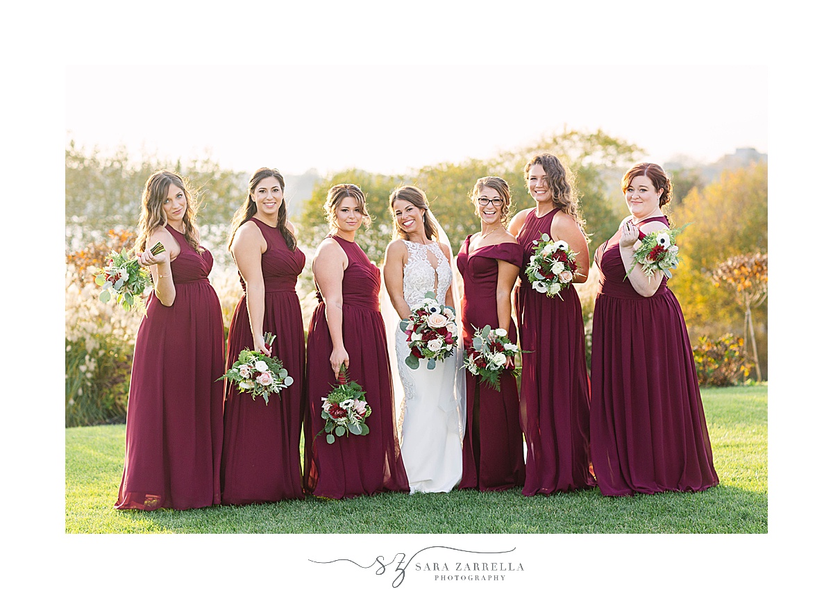 bridesmaids in red pose with bride before fall RI wedding