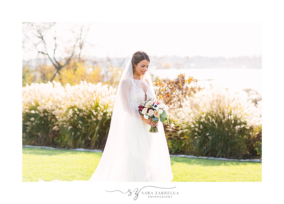 bride looks down at fall bouquet during portraits at Atlantic Resort Newport Wedding