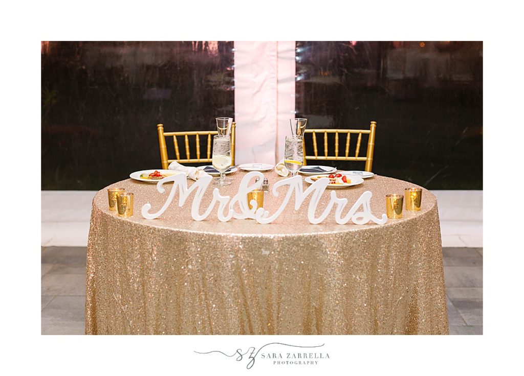 Mrs and Mr signs on sweetheart table with gold table cloth
