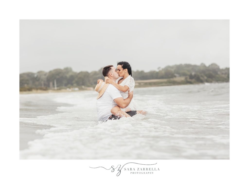 engaged couple kisses in waves on Rhode Island beach