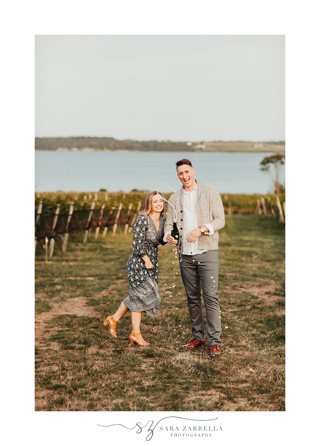 couple pops champagne during engagement photos