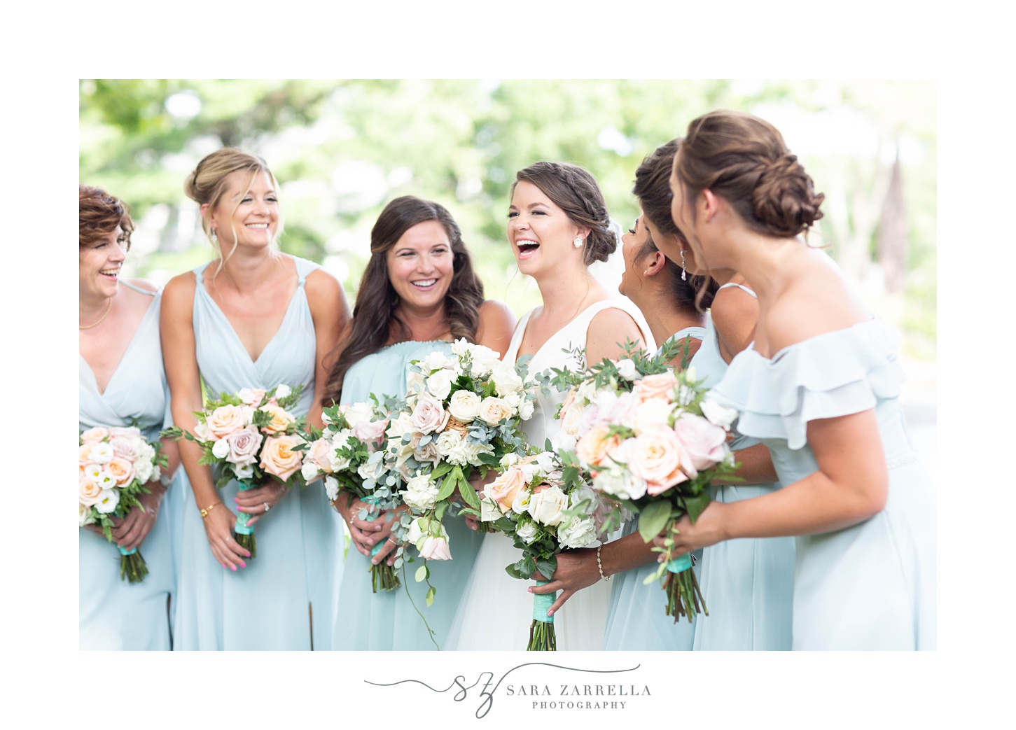bride laughs with bridesmaids in blue gowns