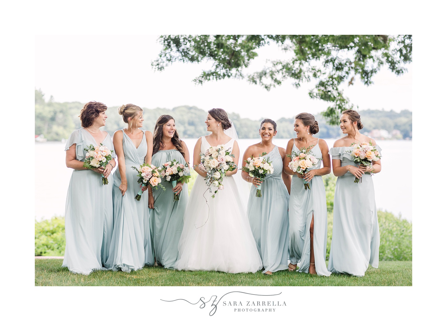 bride laughs with bridesmaids in blue gowns during Rhode Island wedding