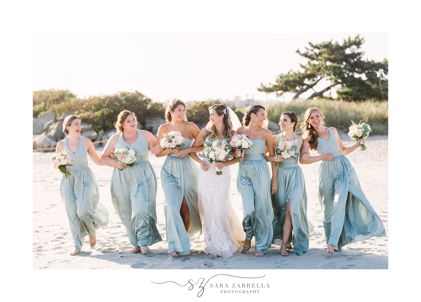 bride walks with bridesmaids on the beach in Rhode Island