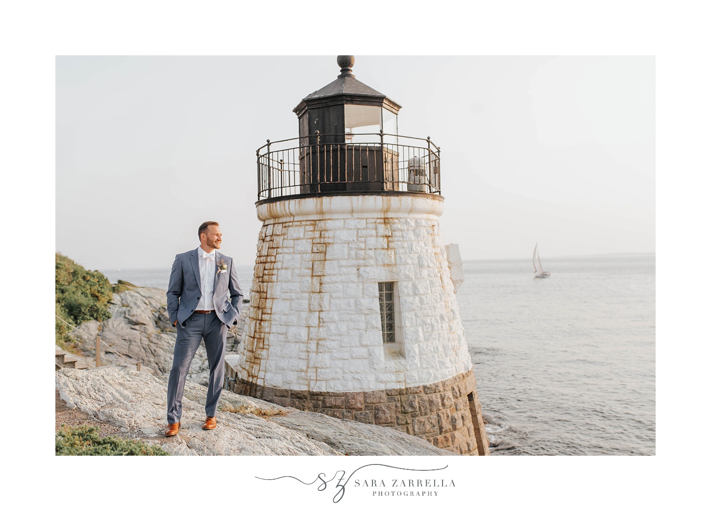 groom looks at bay during Rhode Island wedding portraits
