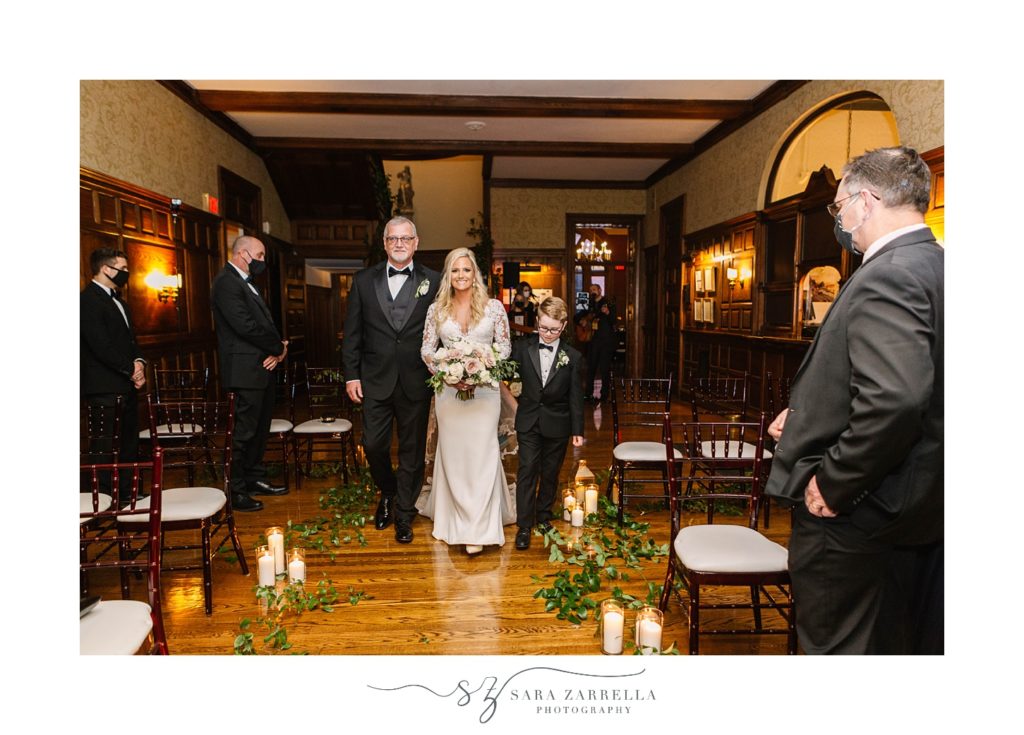 bride walks down aisle with father and son at Hope Club