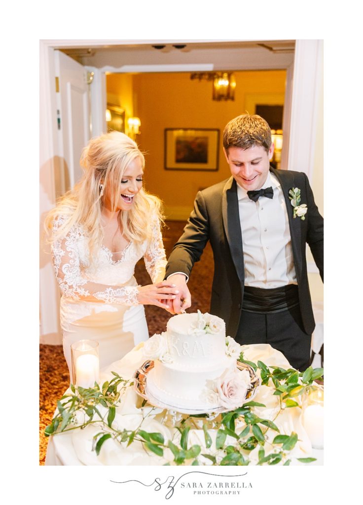 bride and groom cut wedding cake during RI wedding reception