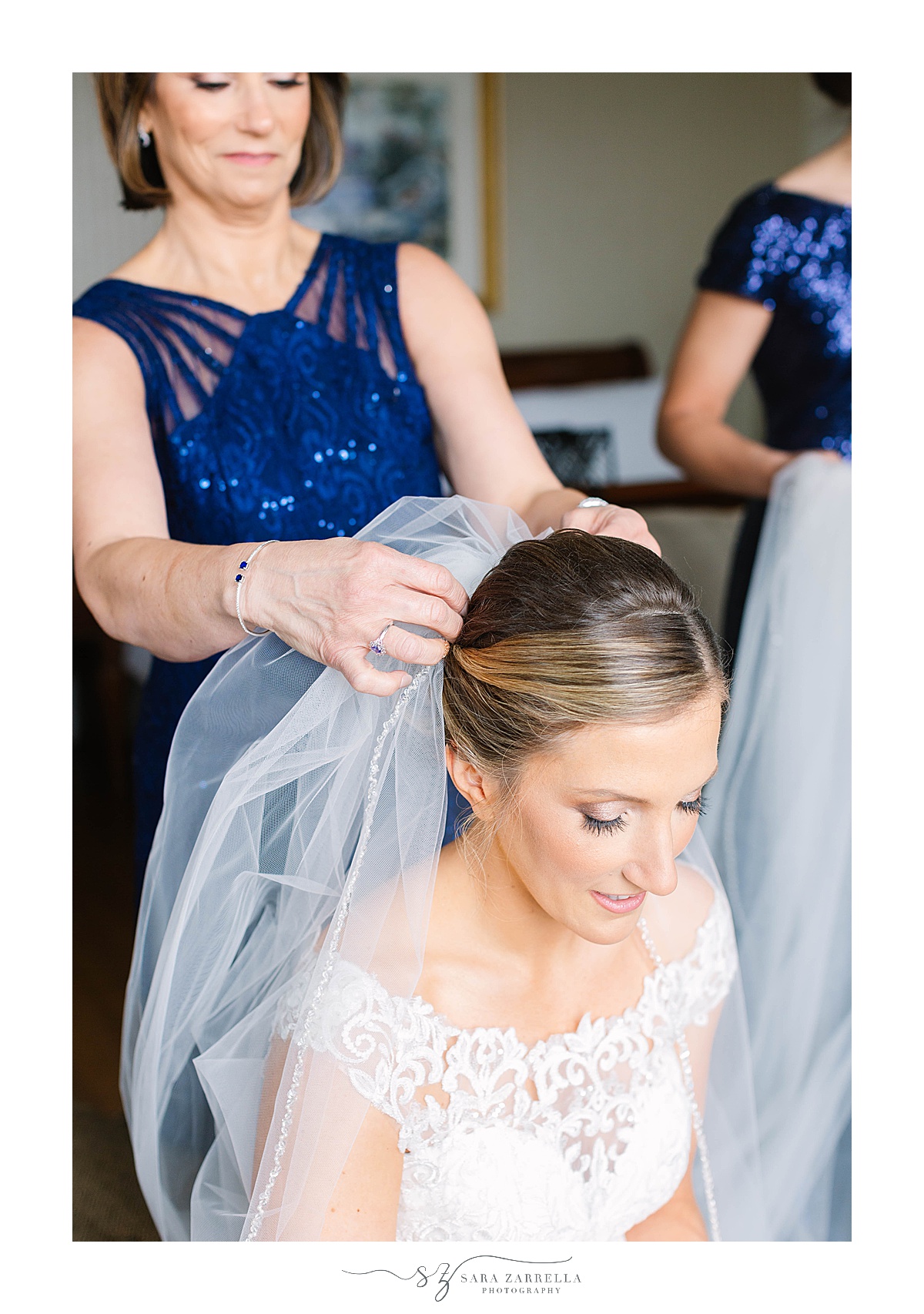 bridesmaid places veil on bride's head